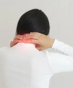Woman holding neck in pain due to cervical dystonia, treated with botulinum for muscle relief